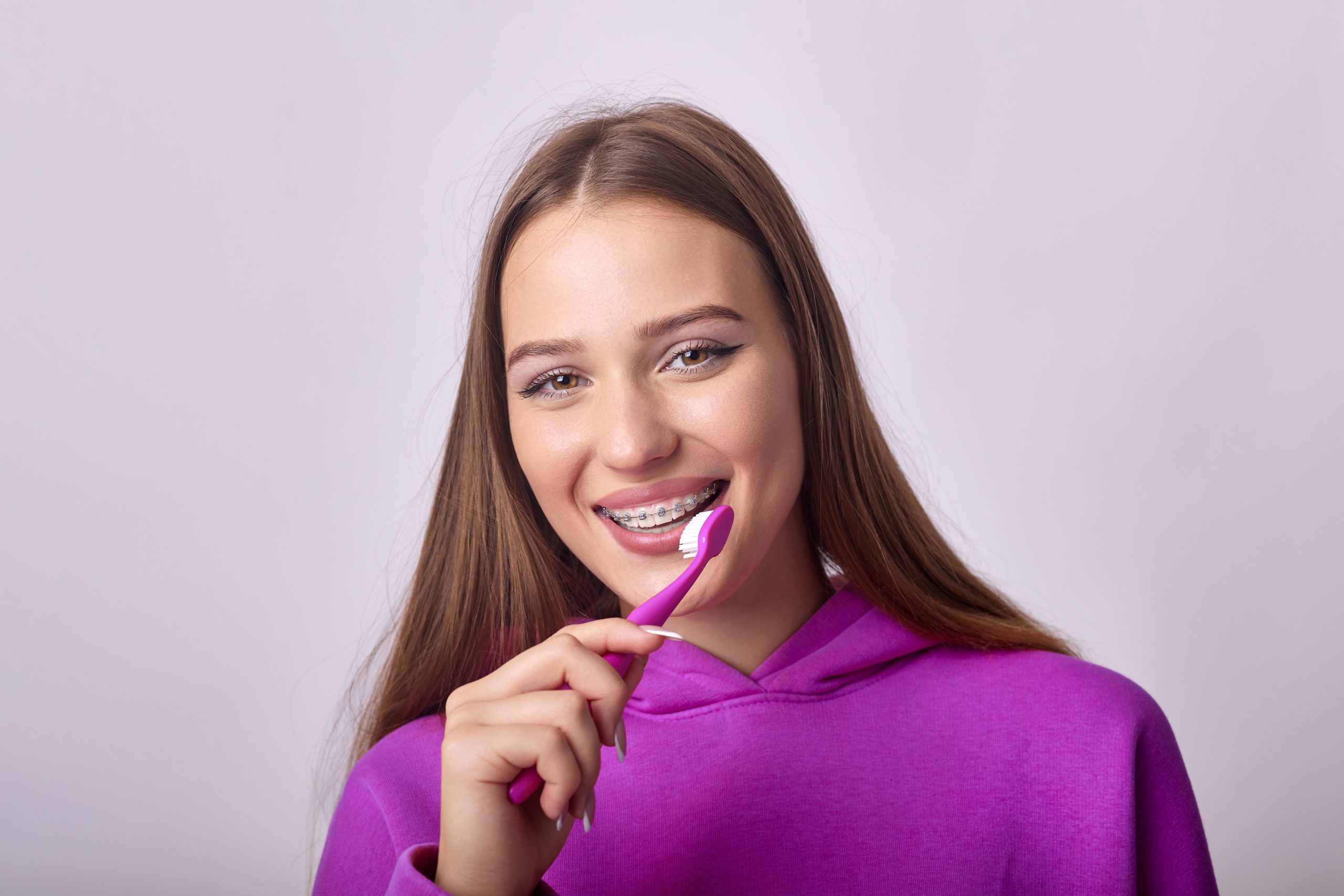 Mujer cepillándose los dientes con cepillo manual