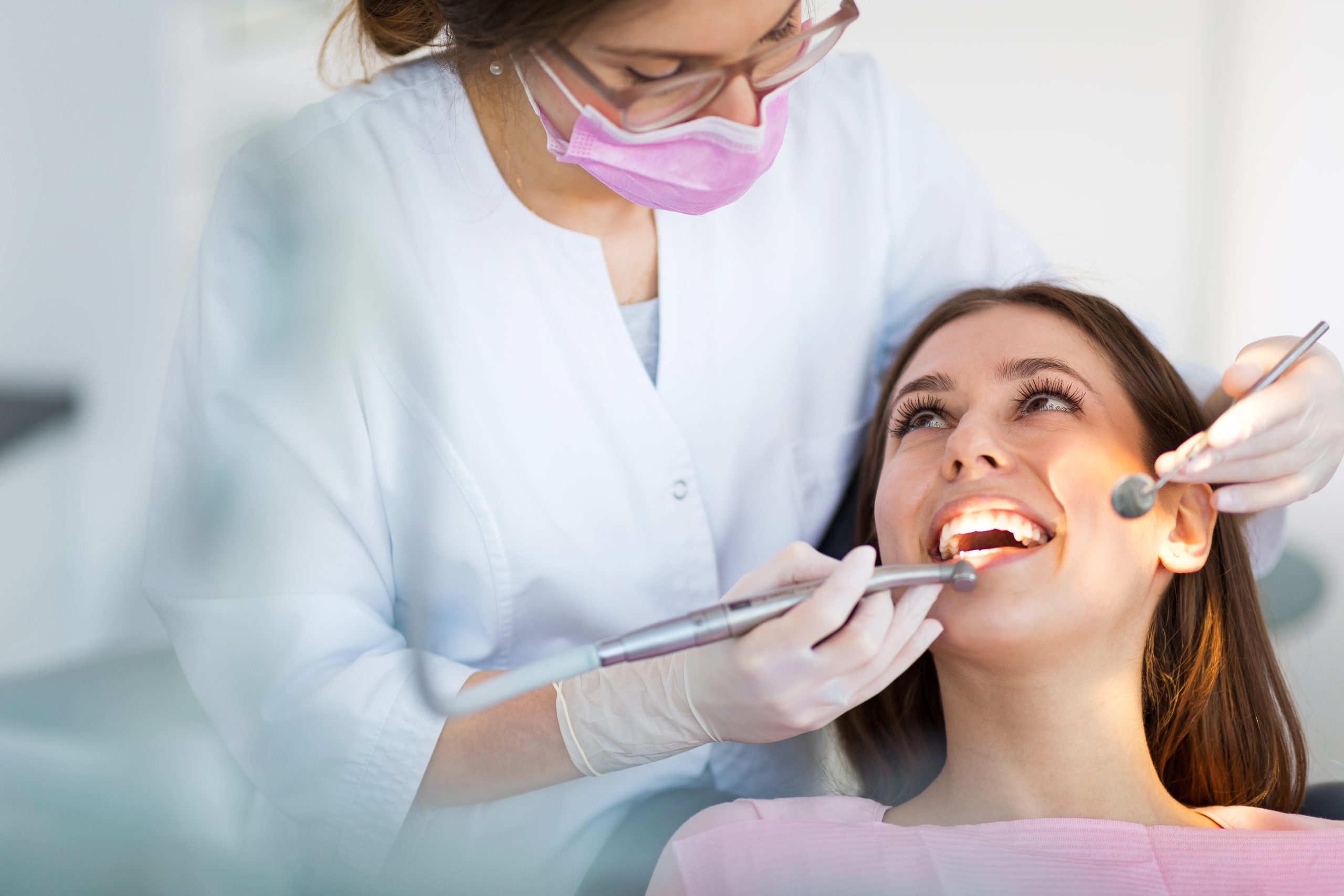Dentista y paciente mujer tranquila en consulta dental