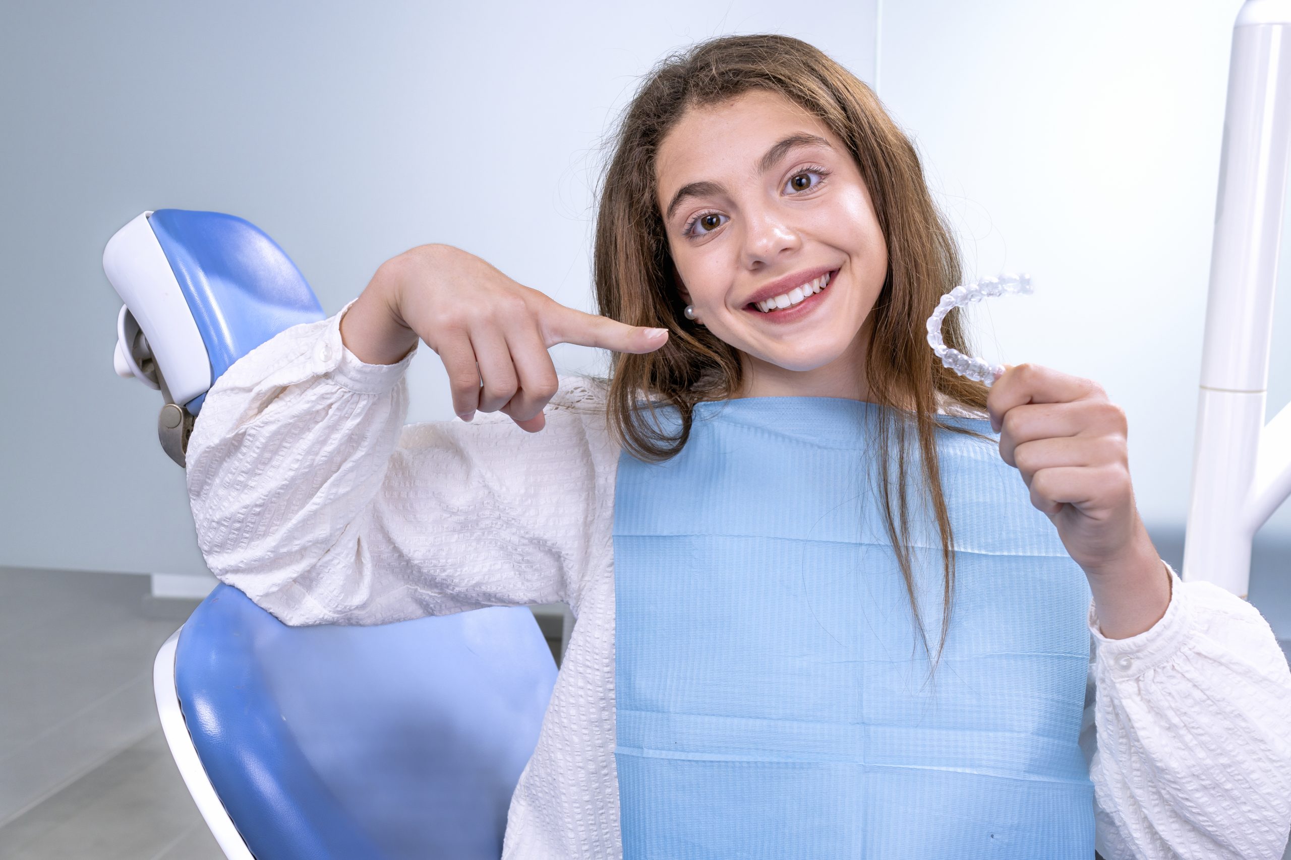 Mujer joven con retenedor dental post tratamiento de ortodoncia