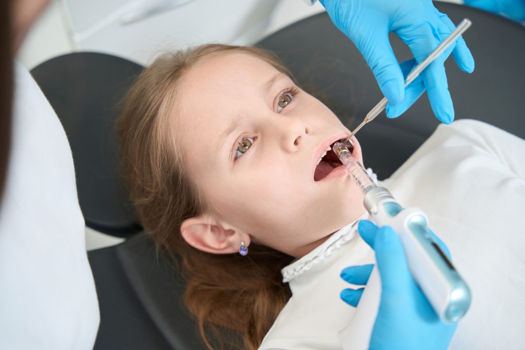 Odontopediatra realizando procedimiento de anestesia dental