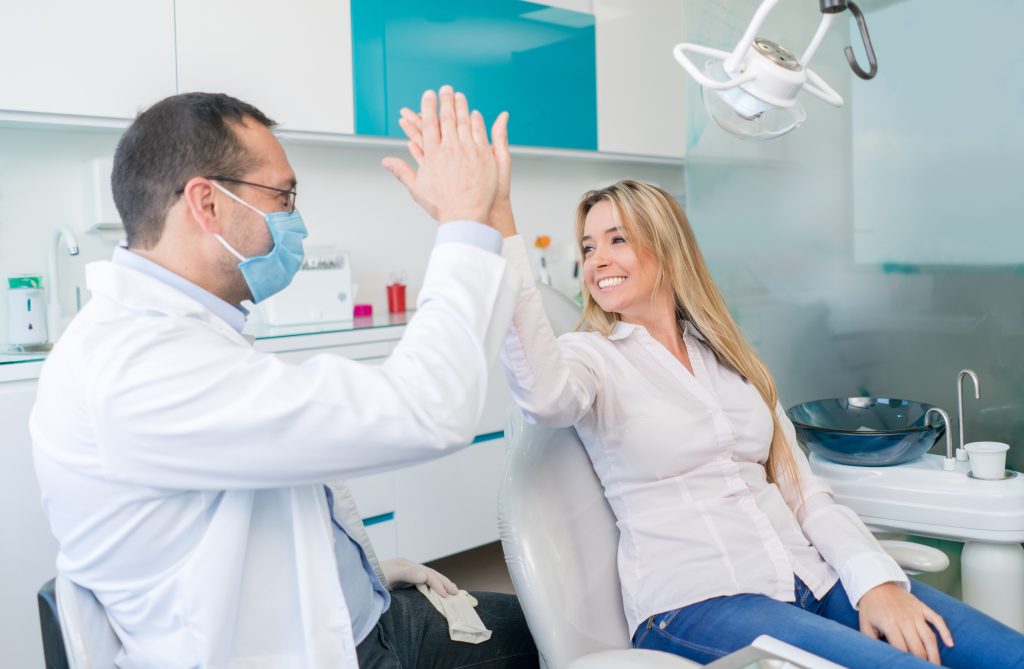 Paciente femenina feliz después de recuperar su diente post tratamiento dental