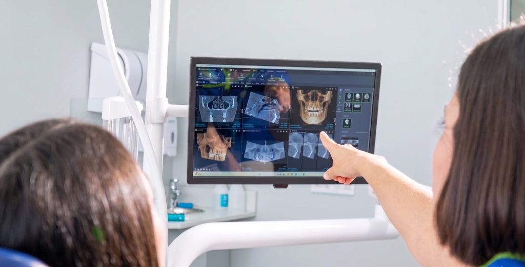 Especialista mostrando a su paciente sus diagnósticos dentales potenciados con IA.