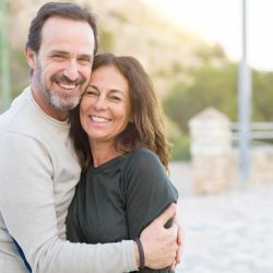 Romantic couple smiling and cuddling on a sunny day