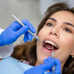 Portrait of a Latin American female patient at the dentist getting her teeth cleaned - dental health concepts